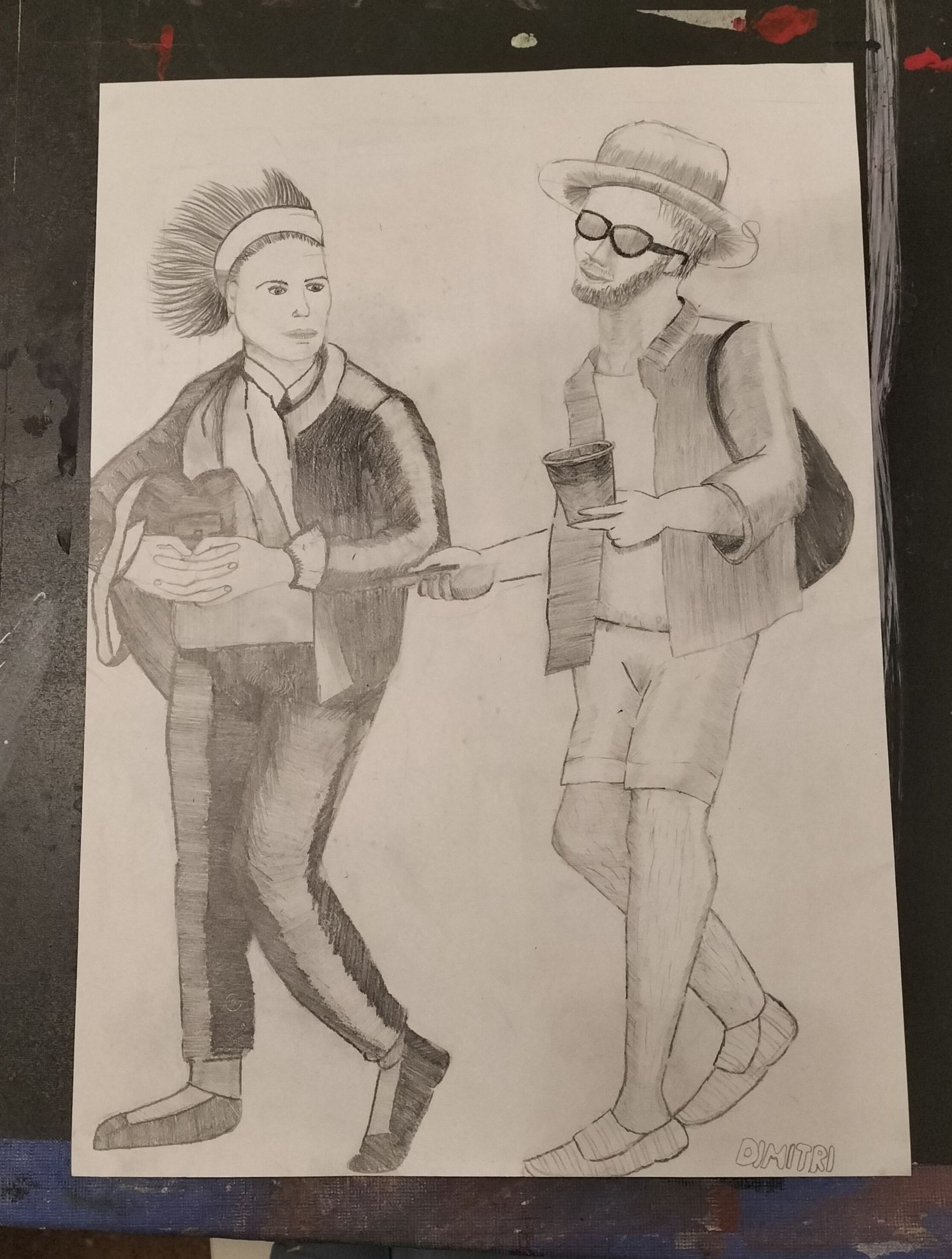 Zwei Personen, eine mit Punkfrisur und ernster Miene, die andere mit Hut und Brille, spazieren gemeinsam und halten eine Tasse