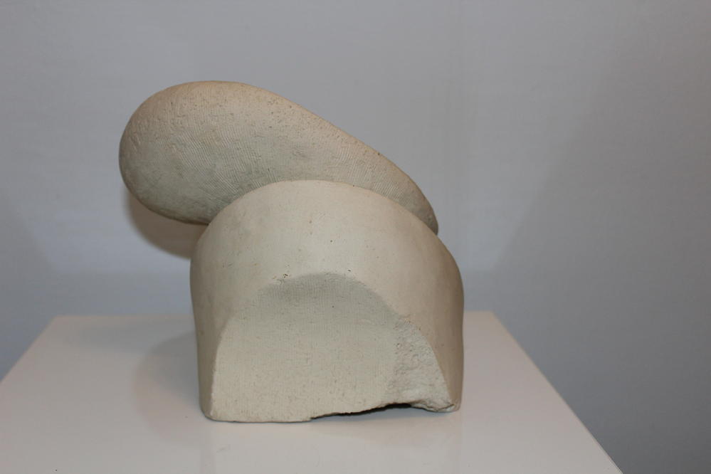 Abstrakte weisse Skulptur mit glatten und rauen Oberflächen und sanften Rundungen