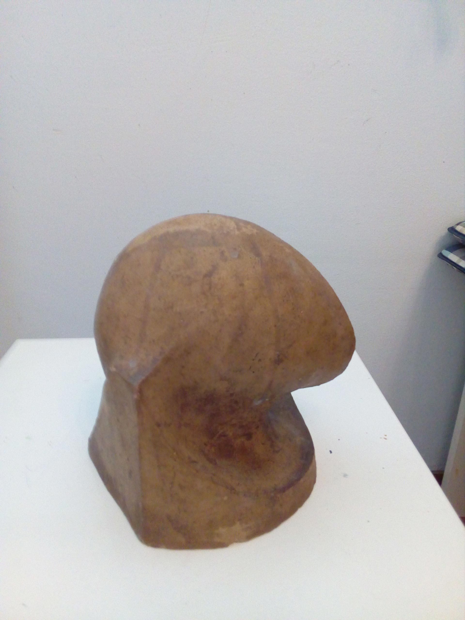 Eine skulpturale Kopfform aus beigefarbenem Material mit glatter, abstrakter Oberfläche