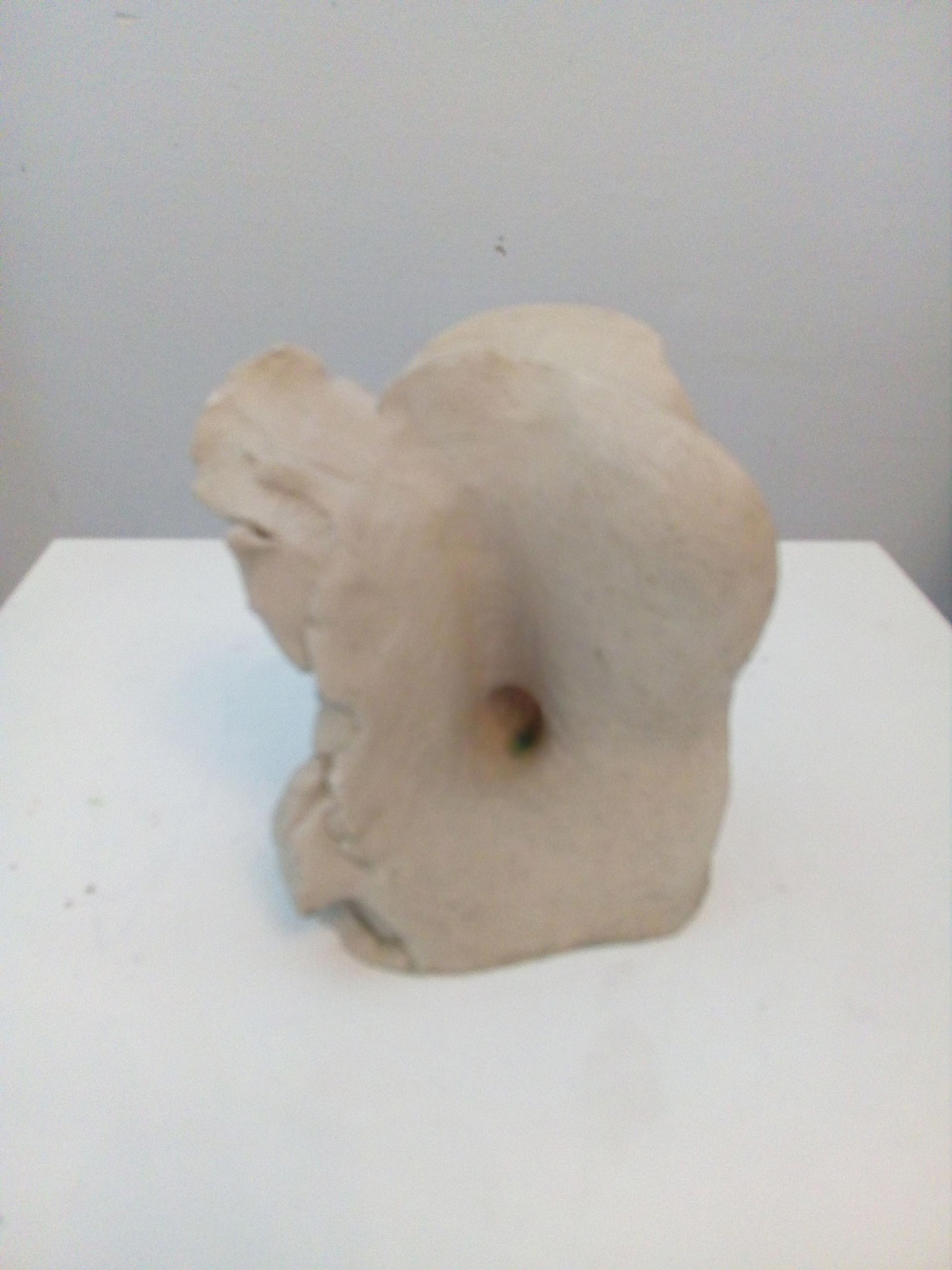 Ein beiger Stein mit unregelmäßigen Formen sowie einer zentralen Vertiefung