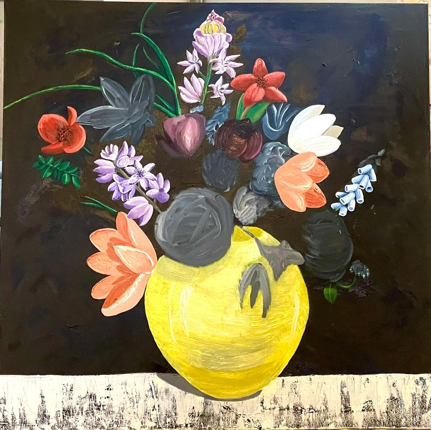 Ein gelber Krug mit bunten und grauen Blumen vor dunklem Hintergrund