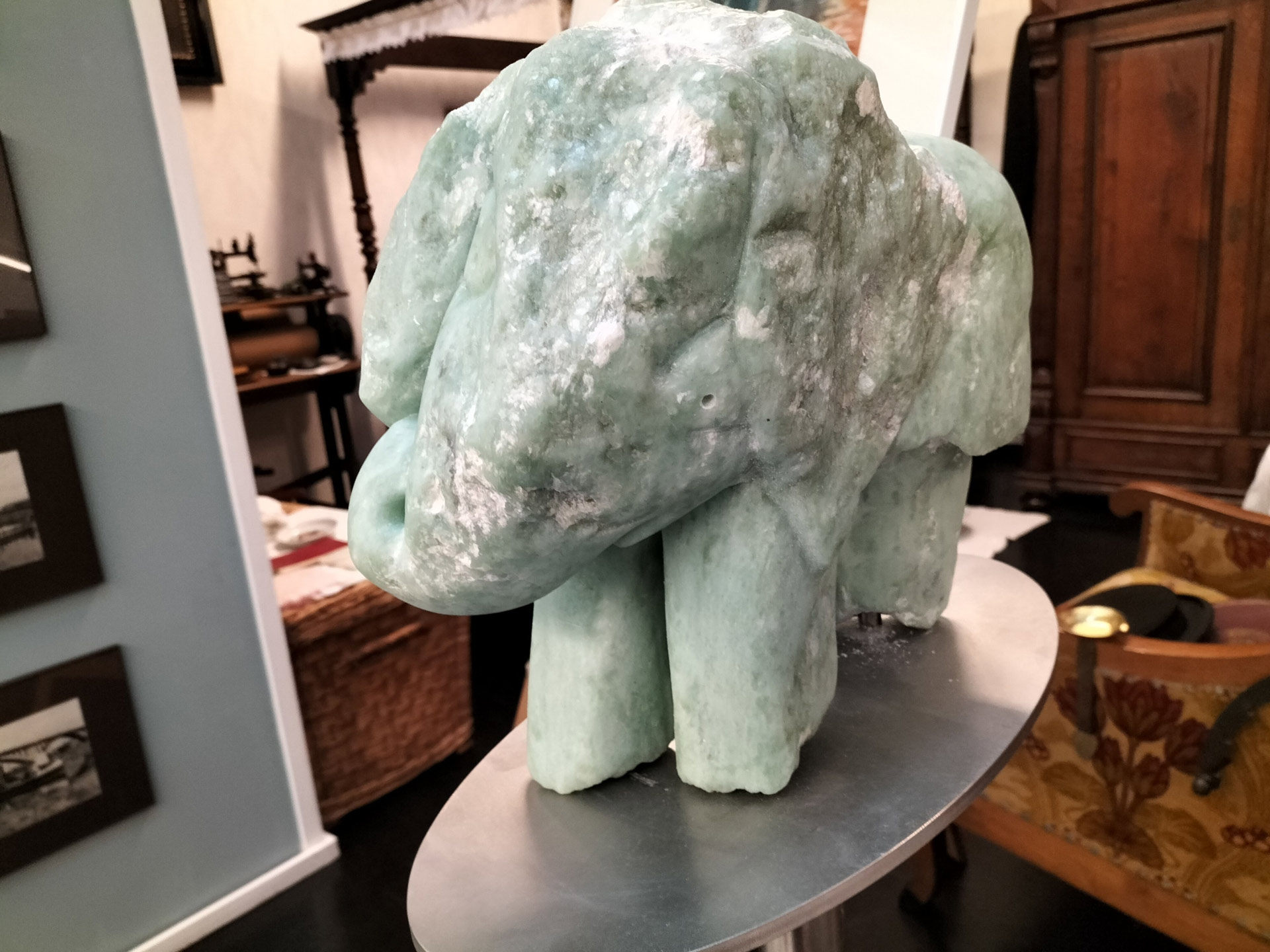 Grüne Steinskulptur in Elefantenform mit weißlichen Flecken in einem Wohnzimmer