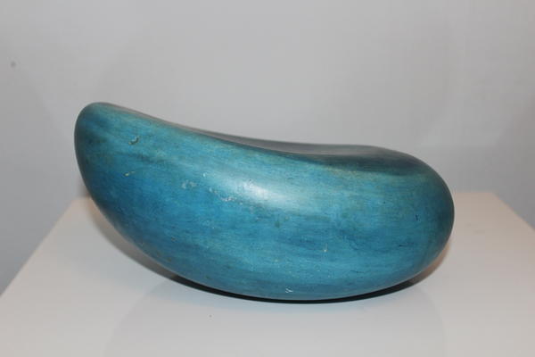 Blaue, glatte Steinskulptur in Bananenform auf weißer Oberfläche