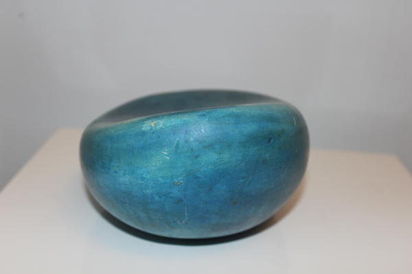 Eine glänzende, blaugrüne Steinskulptur mit glatter, leicht gewölbter Oberfläche