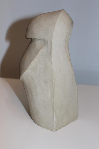 Eine abstrakte helle Skulptur mit klaren Kanten steht auf weißer Fläche