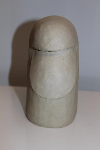 Eine abstrahierte helle Skulptur mit ovalem Gesichtsausdruck und glatter Oberfläche