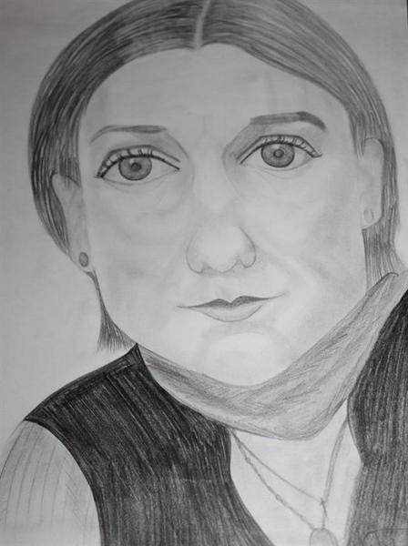 Eine Frau mit ernster Miene, kurzem dunklem Haar und einem dunklen Oberteil