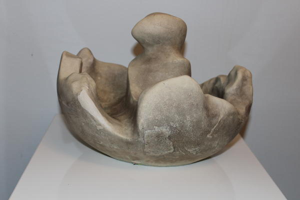 Abstrakte beige Skulptur mit rauer Oberfläche zeigt Figur in einer halbrunden Form