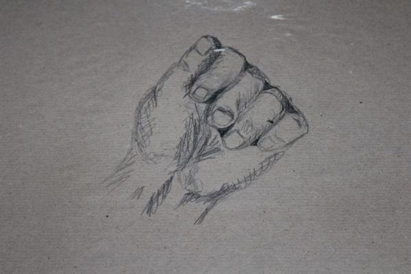 Eine mit Bleistift skizzierte Hand mit geballter Faust auf braunem Papier wirkt kraftvoll