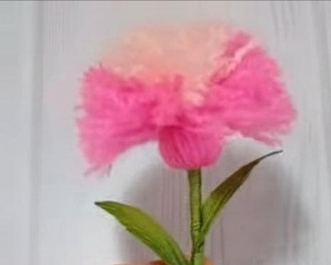 Pinke Stoffblume ohne Gesicht mit flauschigen Blaettern und gruenem Stiel