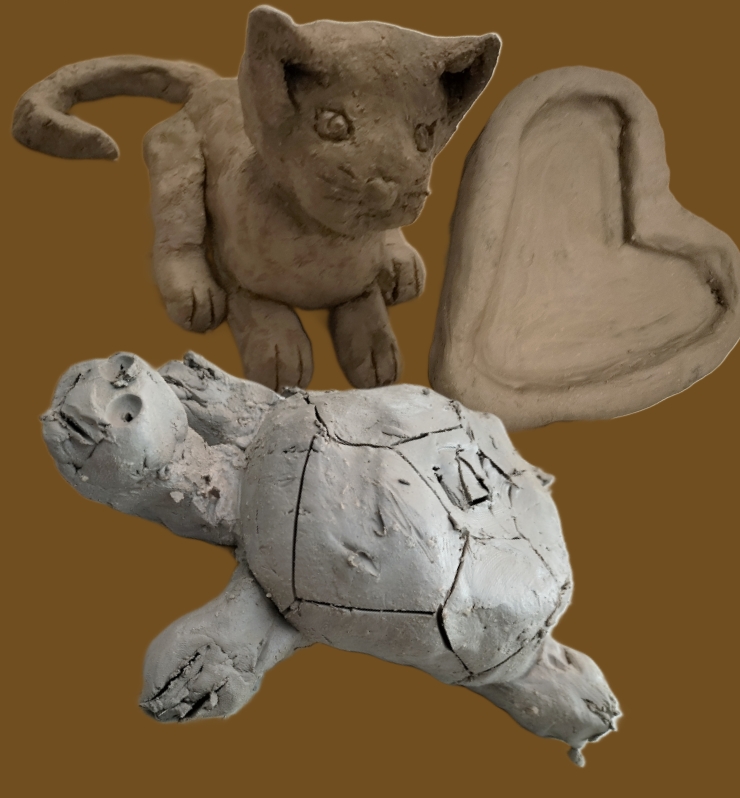 Eine graue Tonkatze mit runden Augen, eine Schildkröte und ein herzförmiges Schälchen