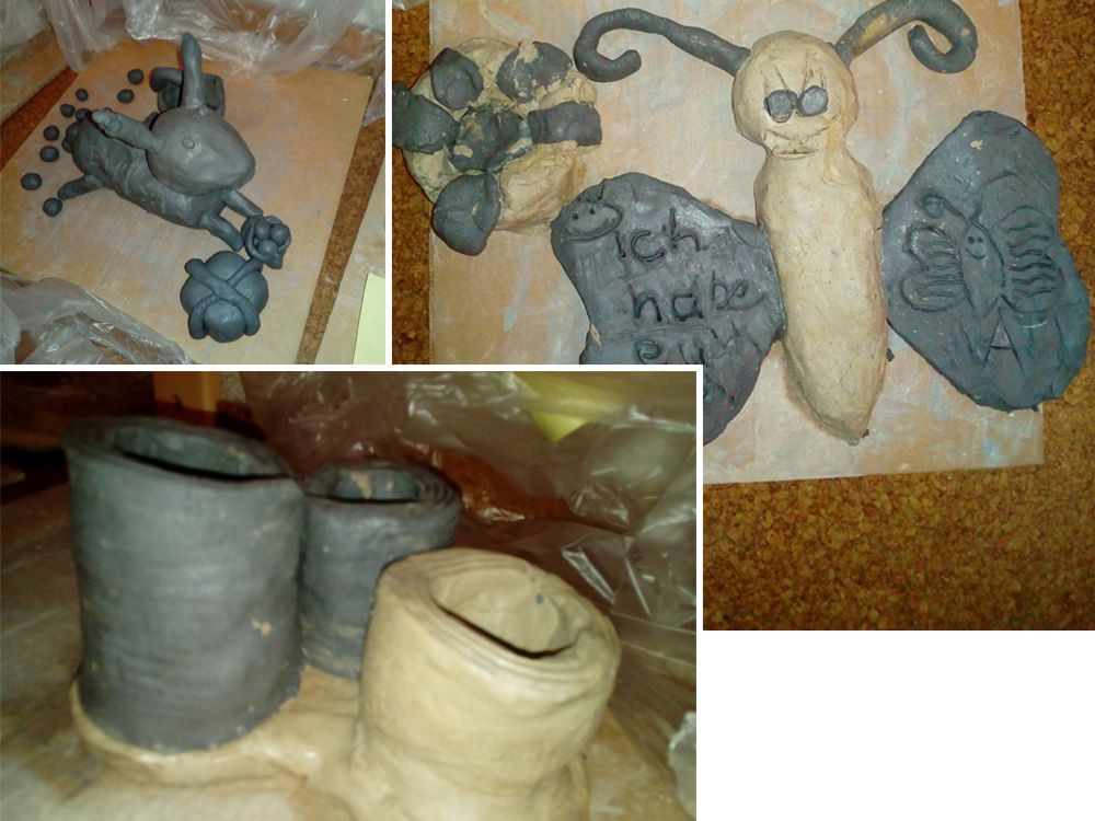 Drei Tonfiguren mit Tiermotiven und Schmetterling, grau und beige, teils bemalt