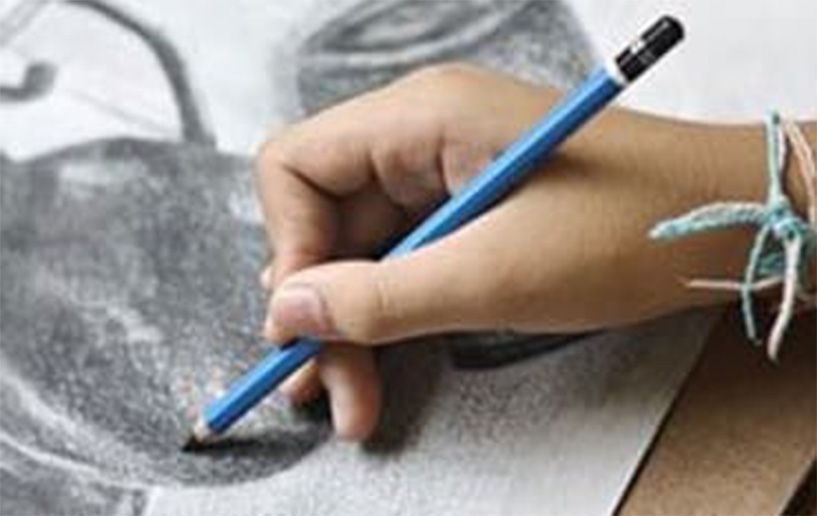 Eine Hand hält einen blauen Bleistift und zeichnet auf einem schwarzweißen Papier