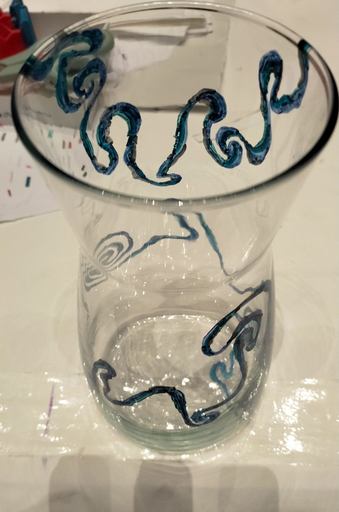 Transparentes Glas mit blaugruenen Wirbeln und Wellenlinien, neutral