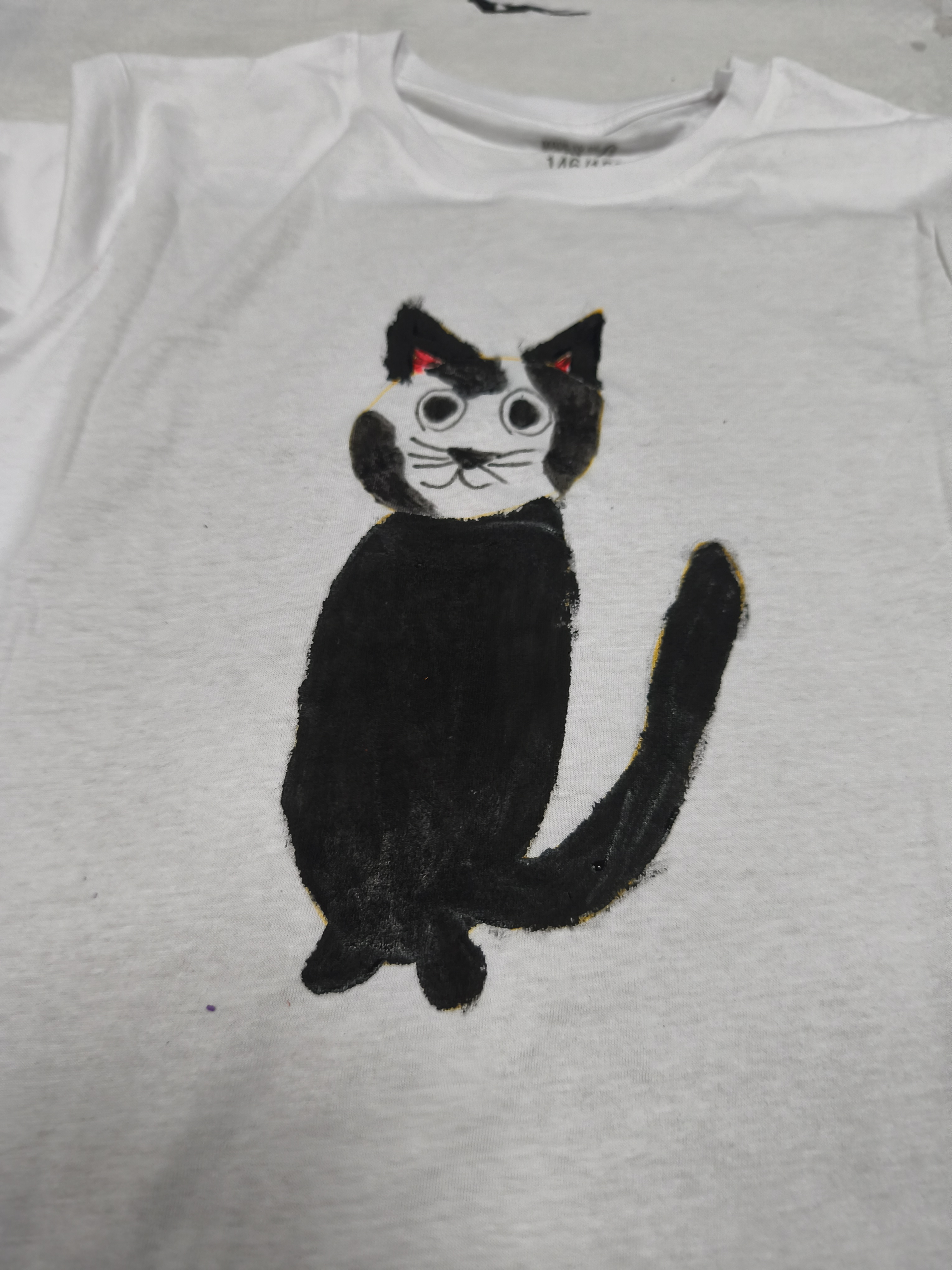 Weisses T Shirt mit schwarzer Katzenzeichnung und grossen Augen, freundlich