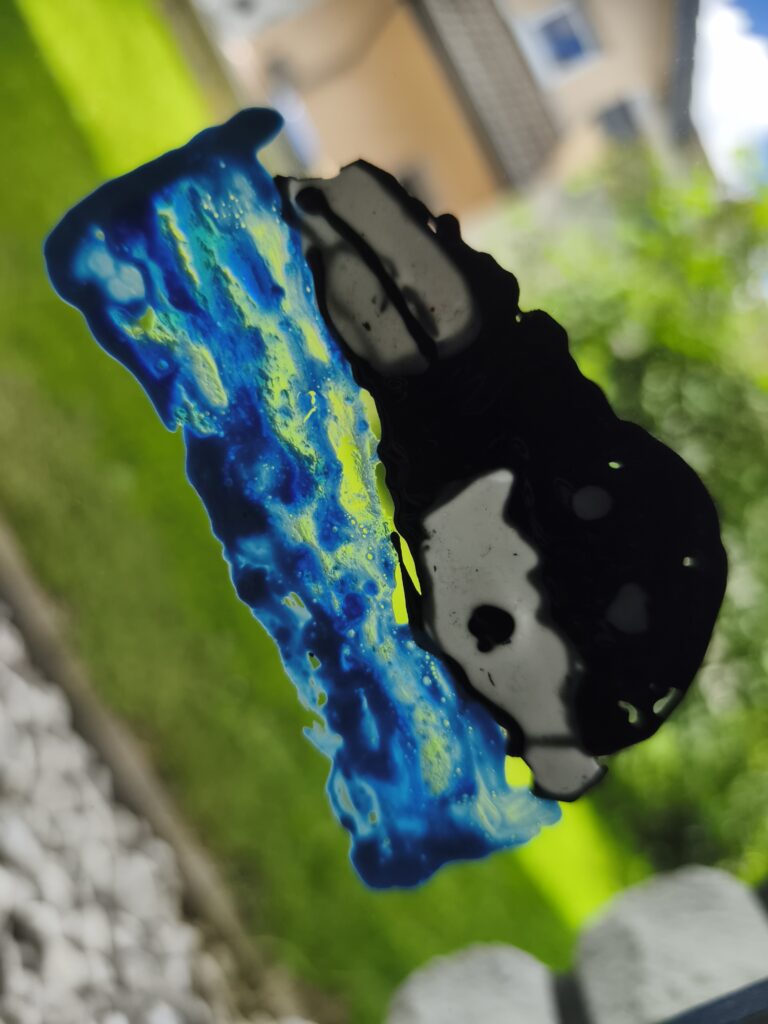 Blaue gelbe und schwarze abstrakte Figur mit Flecken auf Glasfläche